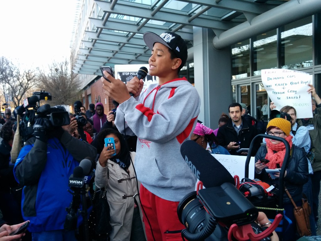 A 14 year old poet name Jalen performs outside police headquarters before a crowd of hundreds. (Photo: Kelly Hayes)