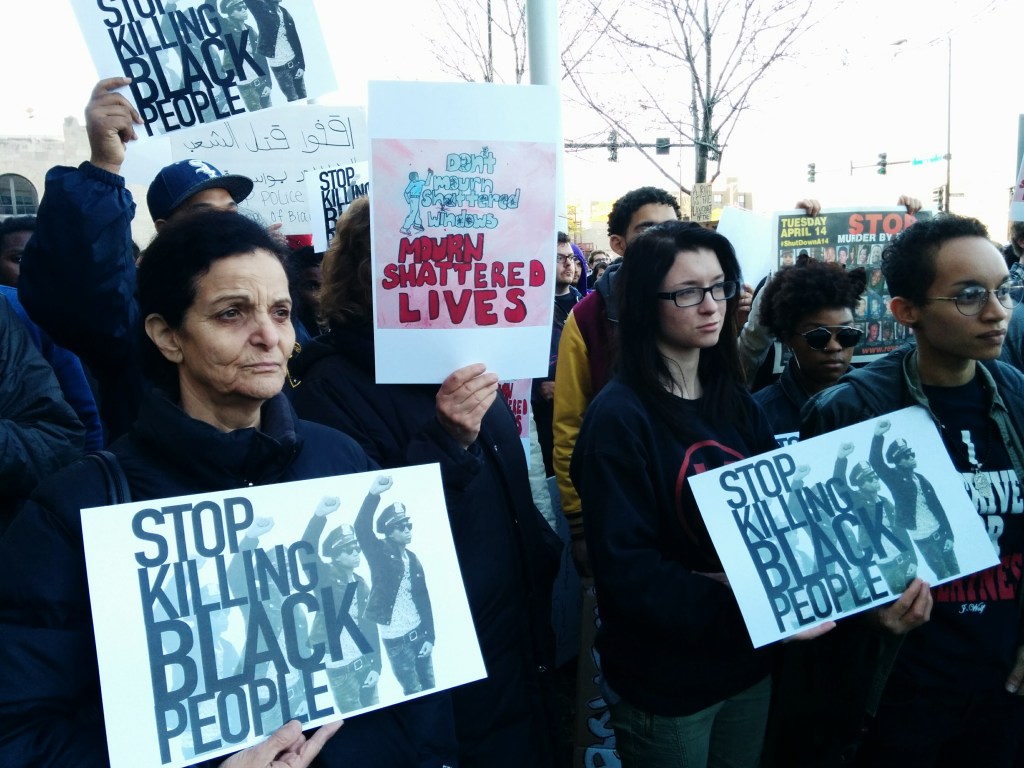 Palestinian Activist Rasmea Odeh holds a sign outside police headquarters on Tuesday. (Photo: Kelly Hayes)