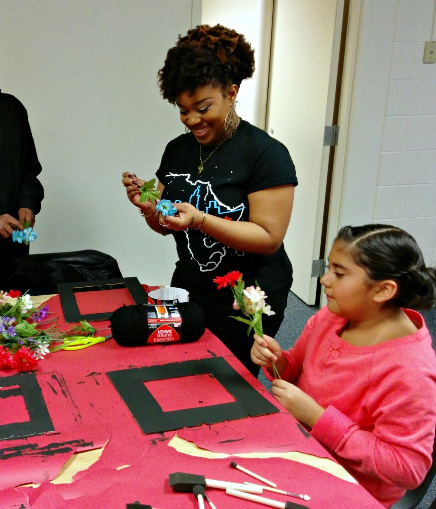 Skill sharer Cairá Lee Conner assists elementary school students who are learning to make protest art. (Photo: Kelly Hayes)