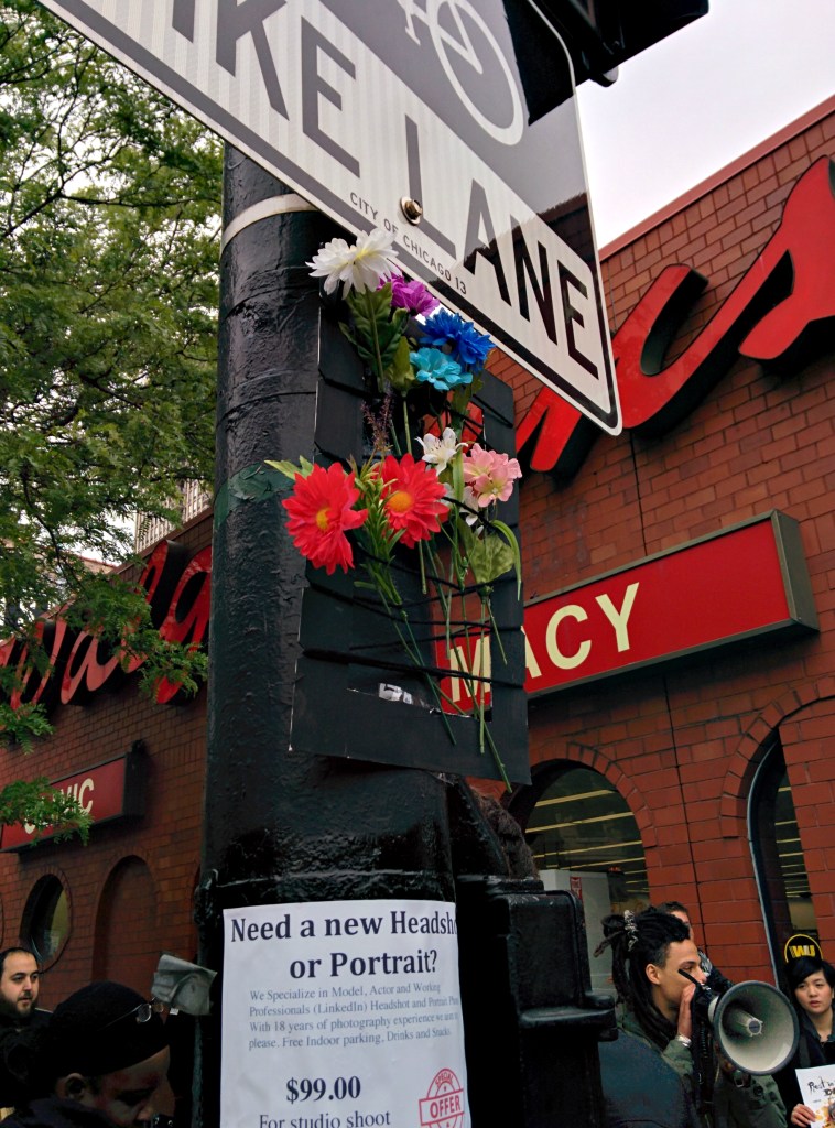 A protestor at Damo Day hangs a loom made by an elementary school student outside the Walgreens where police began their chase of Dominique Franklin last year. The loom's imagery represents life and community overcoming state violence. (Photo: Kelly Hayes)