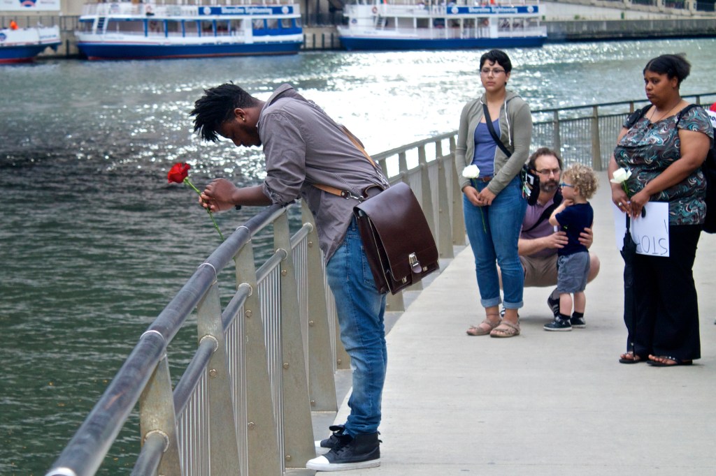 Chicago poet and organizer Malcolm London mourns beside the Chicago River at a vigil for the victims of Wednesday's massacre. (Photo: Bob Simpson)